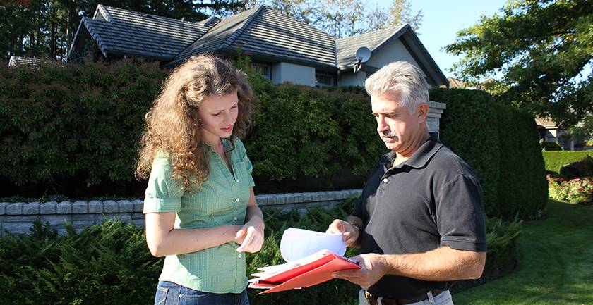 A man showing a woman a binder